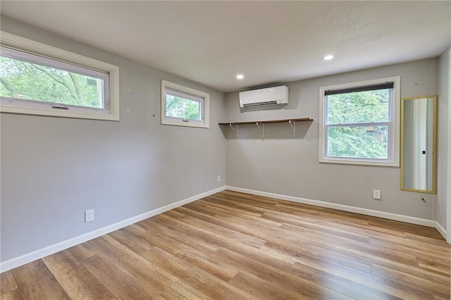 918 W 32nd Ter, Kansas City, MO 64111 - unfurnished room featuring a wall mounted AC, light wood-type flooring, baseboards, healthy amount of natural light, and recessed lighting