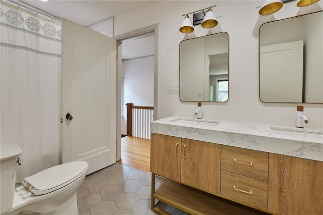918 W 32nd Ter, Kansas City, MO 64111 - bathroom featuring toilet, double vanity, and tile patterned floors