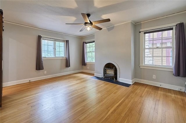 918 W 32nd Ter, Kansas City, MO 64111 - unfurnished living room with light wood-type flooring, ornamental molding, a ceiling fan, baseboards, and a fireplace with flush hearth