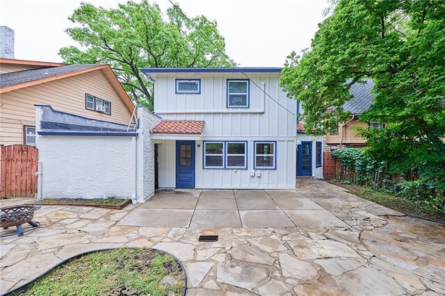 918 W 32nd Ter, Kansas City, MO 64111 - view of front facade with board and batten siding, a fire pit, and a patio area