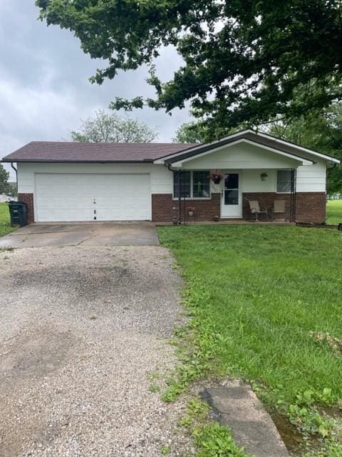 203 N Morrill St, Iola, KS 66749 - single story home with brick siding, driveway, a garage, and a front lawn