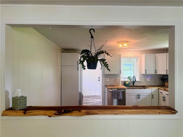 908 N 8th St, Lansing, KS 66043 - kitchen with stainless steel dishwasher, backsplash, white cabinets, and wooden counters