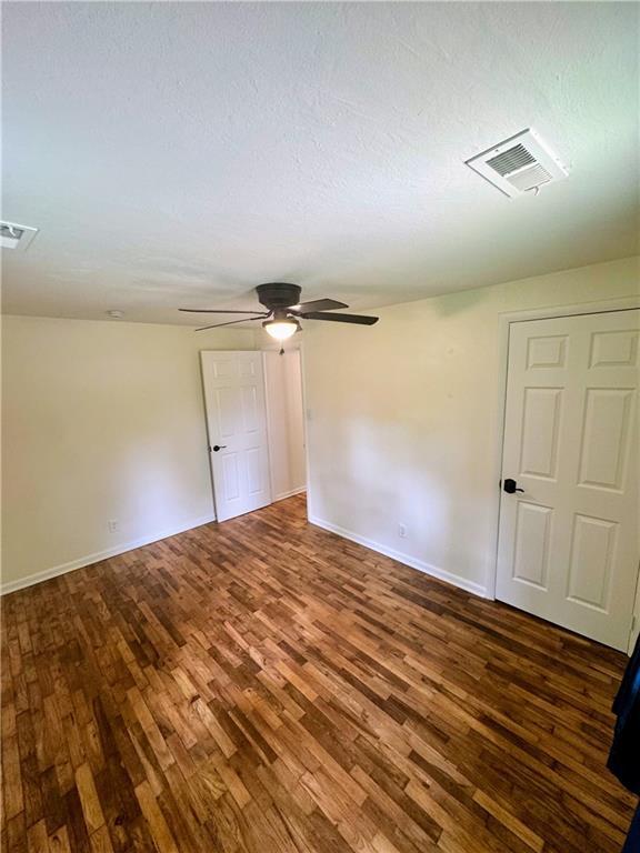 908 N 8th St, Lansing, KS 66043 - spare room featuring wood finished floors, a ceiling fan, attic access, and a textured ceiling