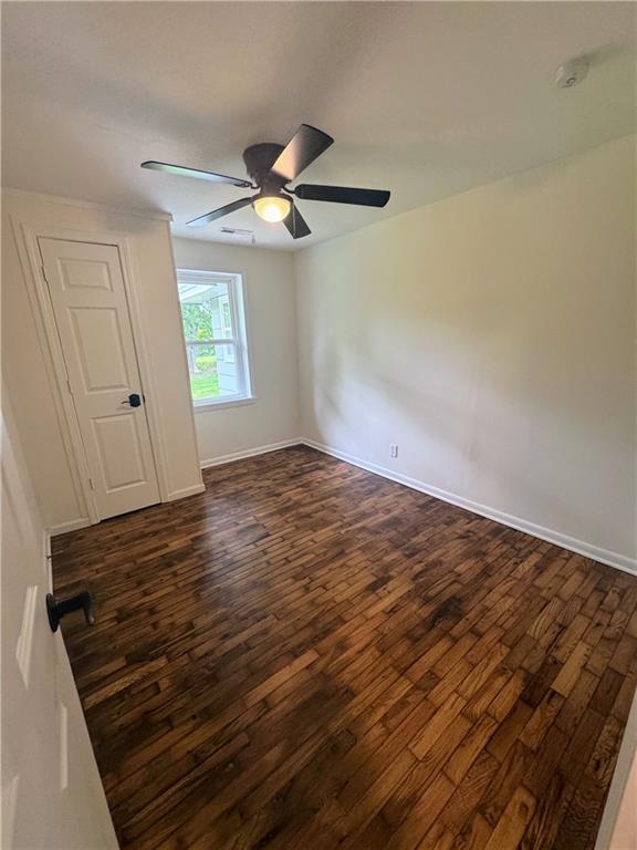 908 N 8th St, Lansing, KS 66043 - spare room featuring dark wood-style flooring, a ceiling fan, and a smoke detector