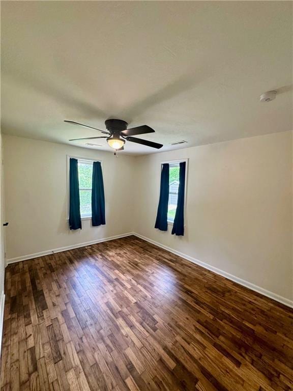 908 N 8th St, Lansing, KS 66043 - spare room featuring plenty of natural light, dark wood-type flooring, ceiling fan, and a smoke detector