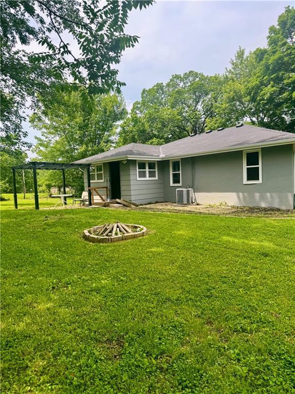 908 N 8th St, Lansing, KS 66043 - back of house with a fire pit and a yard