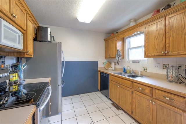 208 N Ohio St, Archie, MO 64725 - kitchen with white microwave, stainless steel electric stove, black dishwasher, a sink, and brown cabinetry