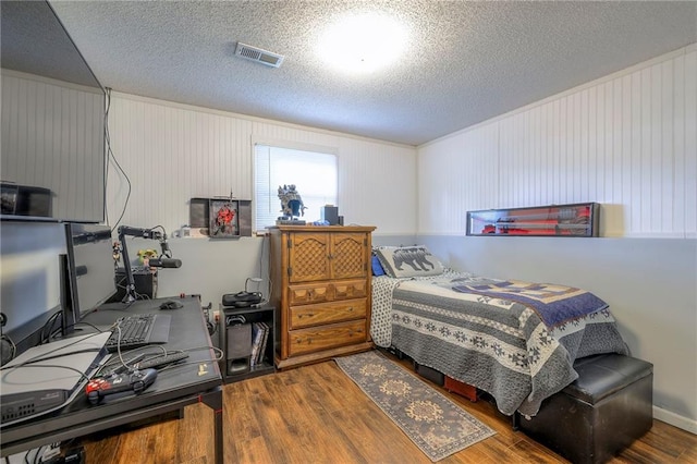 208 N Ohio St, Archie, MO 64725 - bedroom with wood finished floors, a textured ceiling, and a desk