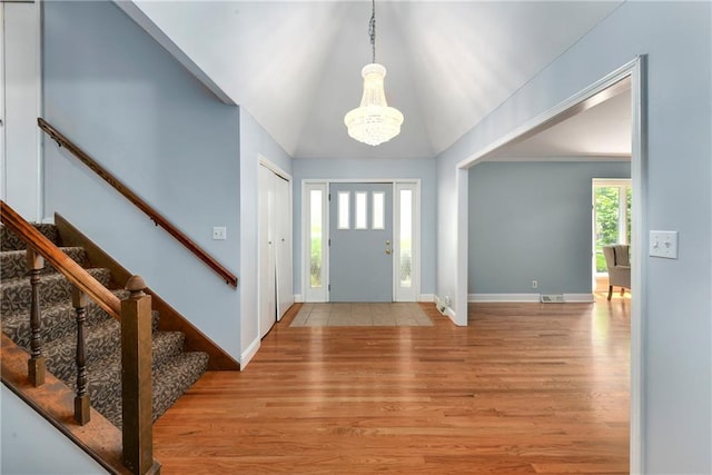 1908 Pine Ridge Dr, Leavenworth, KS 66048 - foyer entrance featuring a chandelier, wood finished floors, stairway, and lofted ceiling
