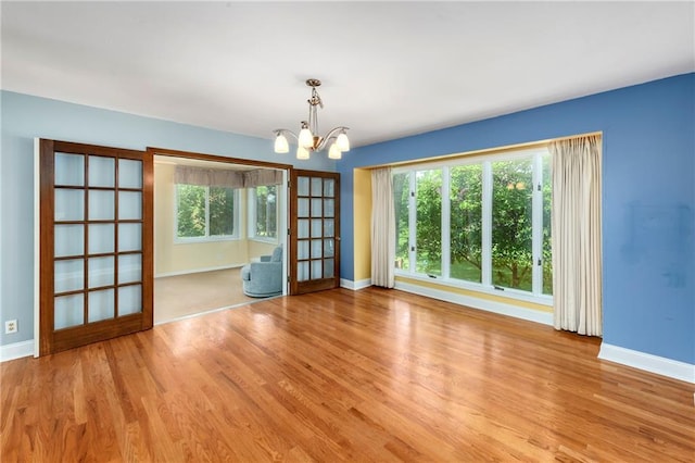 1908 Pine Ridge Dr, Leavenworth, KS 66048 - spare room featuring a chandelier, wood finished floors, and healthy amount of natural light