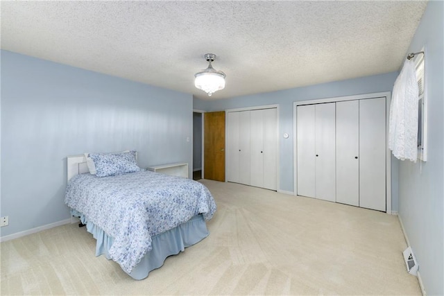 1908 Pine Ridge Dr, Leavenworth, KS 66048 - carpeted bedroom with two closets and a textured ceiling