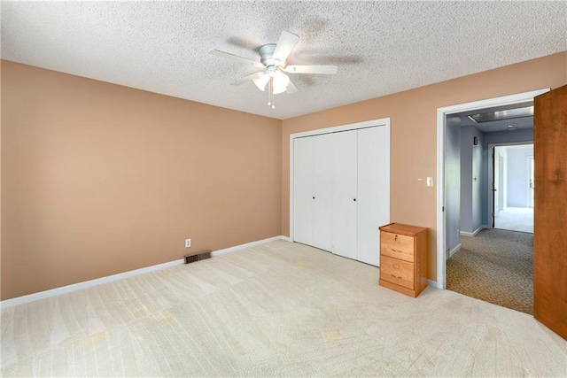 1908 Pine Ridge Dr, Leavenworth, KS 66048 - unfurnished bedroom featuring light colored carpet, a closet, a ceiling fan, and a textured ceiling