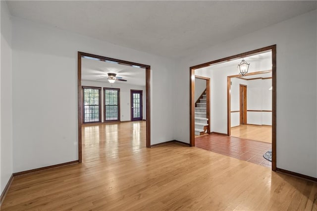 8541 Oakview Dr, Lenexa, KS 66215 - unfurnished room with stairs, light wood-style floors, a chandelier, and ceiling fan