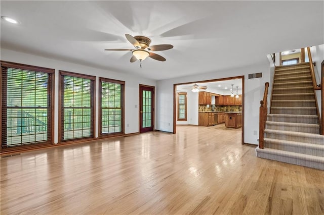 8541 Oakview Dr, Lenexa, KS 66215 - unfurnished living room with a ceiling fan, light wood-type flooring, stairs, and recessed lighting