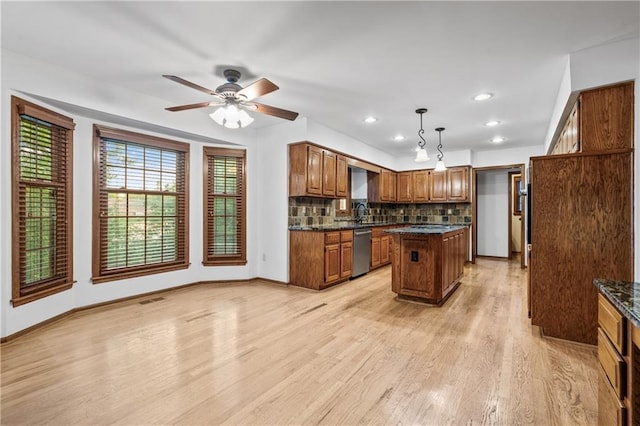 8541 Oakview Dr, Lenexa, KS 66215 - kitchen featuring dishwasher, brown cabinets, light wood-type flooring, decorative backsplash, and a kitchen island