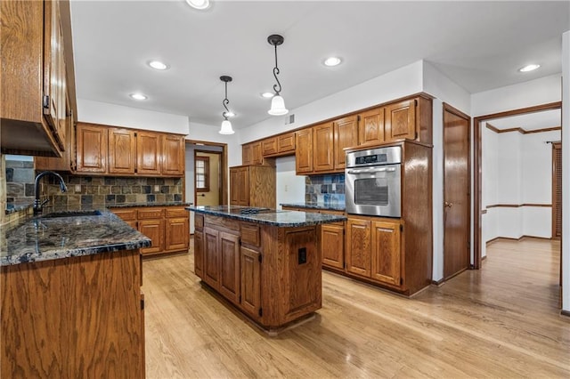 8541 Oakview Dr, Lenexa, KS 66215 - kitchen featuring oven, brown cabinets, light wood-style flooring, and recessed lighting