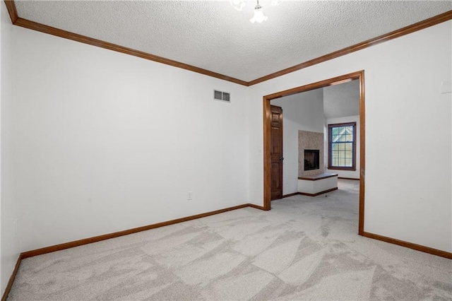 8541 Oakview Dr, Lenexa, KS 66215 - empty room featuring a textured ceiling, light colored carpet, a fireplace with raised hearth, and crown molding