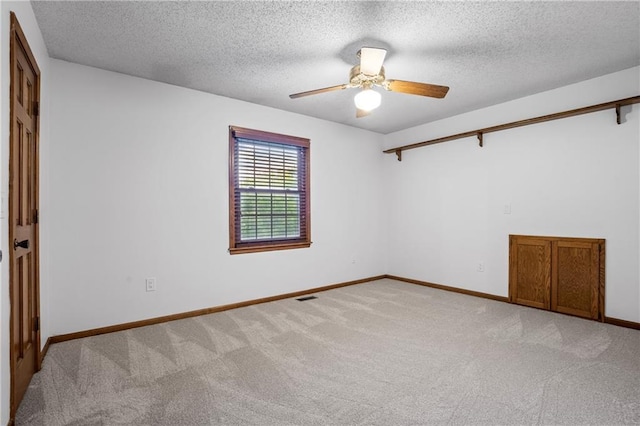8541 Oakview Dr, Lenexa, KS 66215 - spare room featuring light colored carpet, ceiling fan, and a textured ceiling