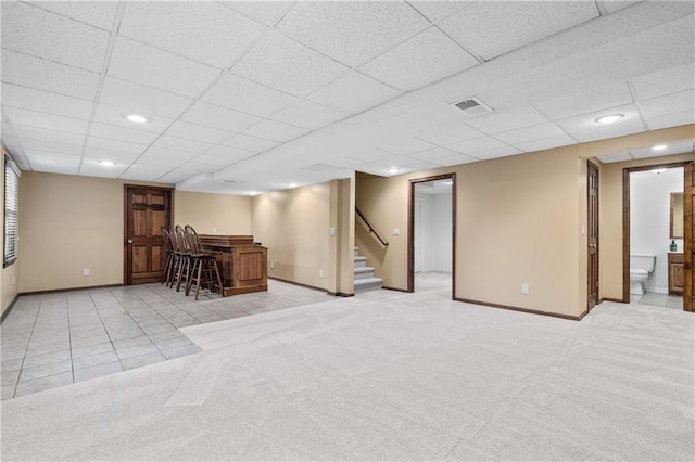 8541 Oakview Dr, Lenexa, KS 66215 - indoor dry bar with stairway, a paneled ceiling, light carpet, and light tile patterned floors