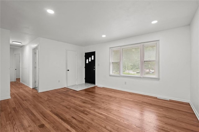 3501 N Delaware St, Independence, MO 64050 - unfurnished living room featuring baseboards, wood finished floors, and recessed lighting