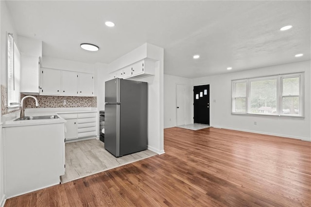 3501 N Delaware St, Independence, MO 64050 - kitchen with freestanding refrigerator, a sink, light wood finished floors, light countertops, and white cabinetry