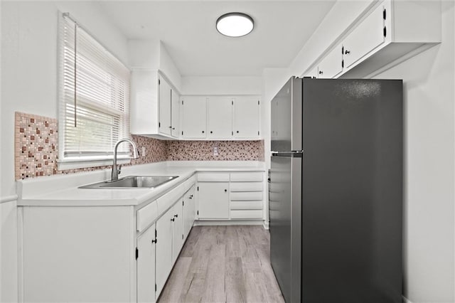 3501 N Delaware St, Independence, MO 64050 - kitchen with freestanding refrigerator, a sink, light wood-style floors, and white cabinets