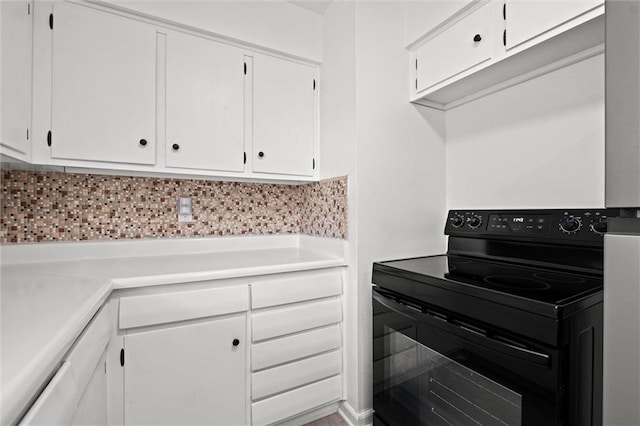 3501 N Delaware St, Independence, MO 64050 - kitchen featuring electric range, white cabinetry, light countertops, and tasteful backsplash