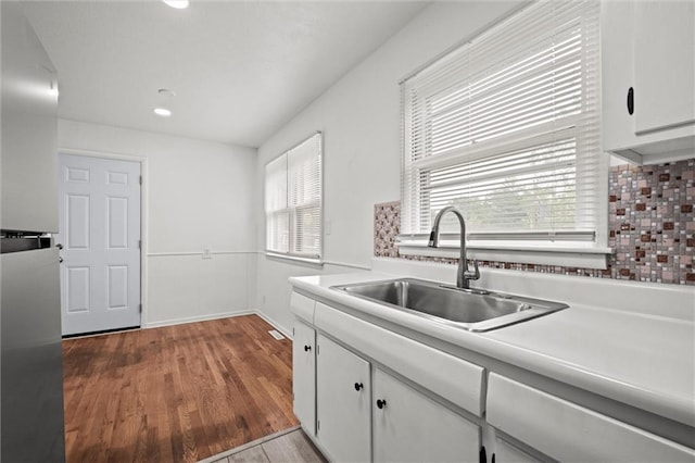 3501 N Delaware St, Independence, MO 64050 - kitchen with a sink, white cabinets, wood finished floors, light countertops, and baseboards