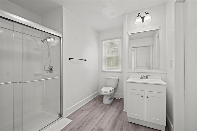 3501 N Delaware St, Independence, MO 64050 - bathroom featuring vanity, toilet, a stall shower, wood finished floors, and baseboards