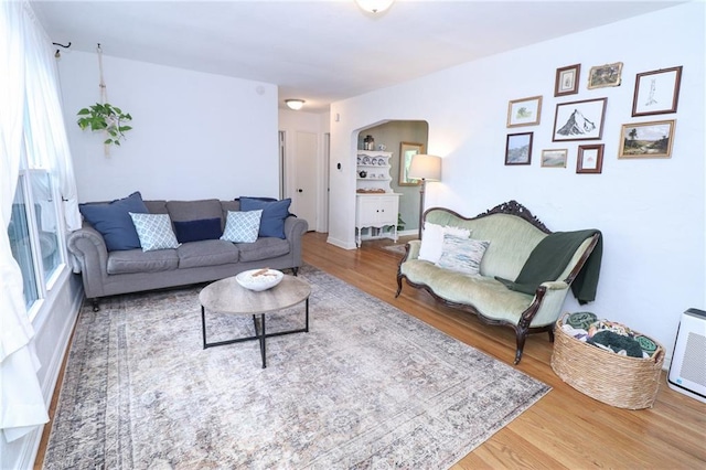 5904 N Howard Ave, Gladstone, MO 64118 - living area featuring arched walkways, wood finished floors, and plenty of natural light