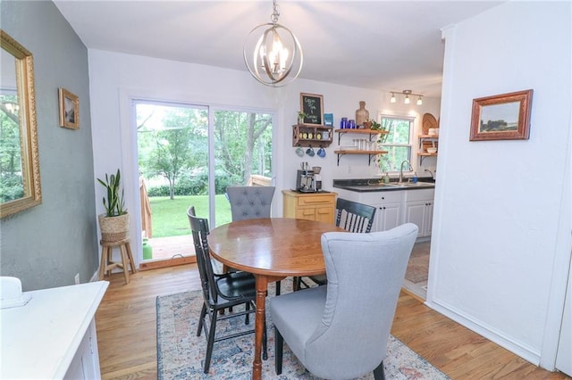 5904 N Howard Ave, Gladstone, MO 64118 - dining space featuring a chandelier, light wood-style flooring, and healthy amount of natural light