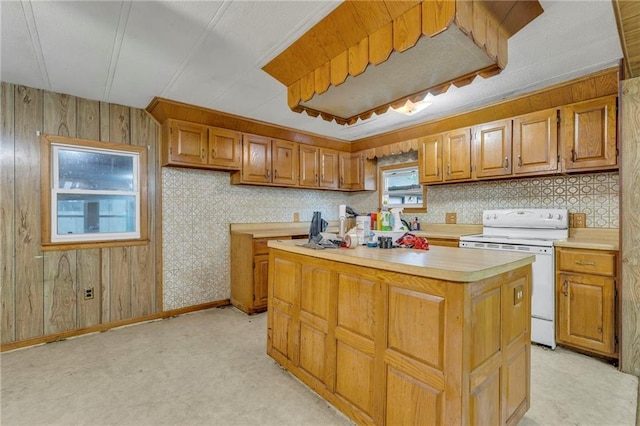 39135 Plum Creek Rd, Osawatomie, KS 66064 - kitchen featuring white electric range oven, light countertops, brown cabinetry, a center island, and wood walls