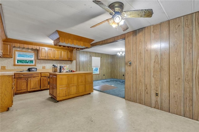 39135 Plum Creek Rd, Osawatomie, KS 66064 - kitchen with light countertops, wooden walls, brown cabinets, and a ceiling fan