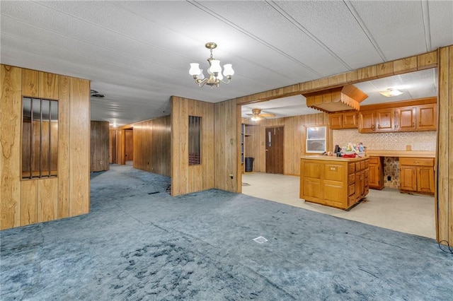 39135 Plum Creek Rd, Osawatomie, KS 66064 - kitchen featuring open floor plan, light carpet, brown cabinetry, wooden walls, and a chandelier