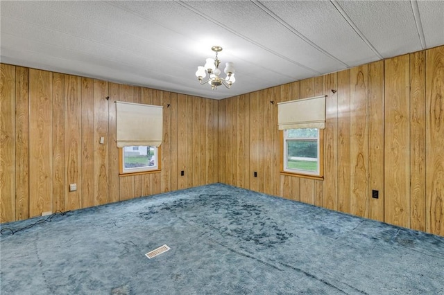 39135 Plum Creek Rd, Osawatomie, KS 66064 - spare room featuring healthy amount of natural light, carpet flooring, wooden walls, and a chandelier