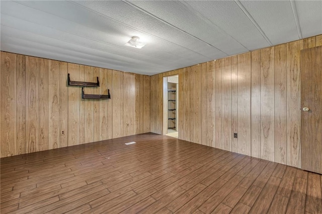 39135 Plum Creek Rd, Osawatomie, KS 66064 - empty room featuring wood walls, wood finished floors, and a textured ceiling