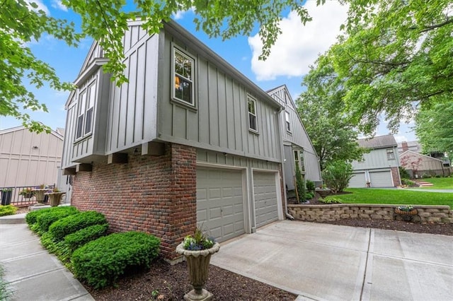 4325 W 112th St, Leawood, KS 66211 - view of property exterior featuring board and batten siding, brick siding, driveway, and an attached garage