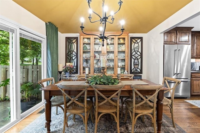 4325 W 112th St, Leawood, KS 66211 - dining space with a chandelier, wood finished floors, and lofted ceiling