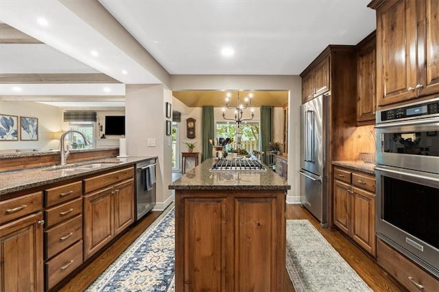4325 W 112th St, Leawood, KS 66211 - kitchen with appliances with stainless steel finishes, dark stone countertops, a chandelier, dark wood-type flooring, and recessed lighting