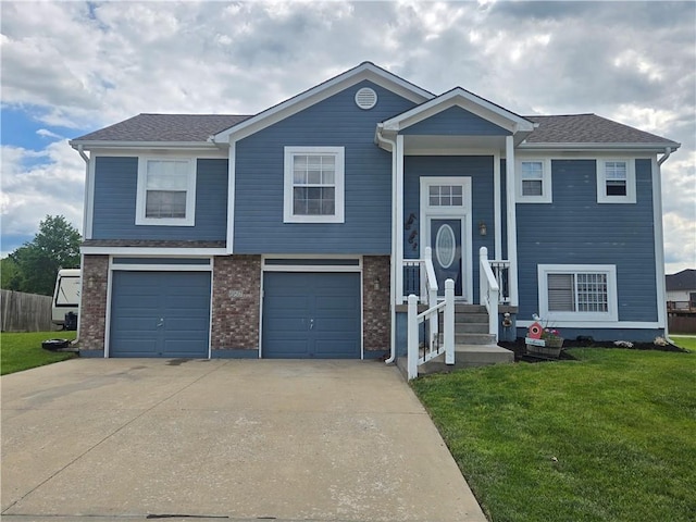 657 SW Tisha Ln, Grain Valley, MO 64029 - bi-level home with concrete driveway, a front lawn, and a garage