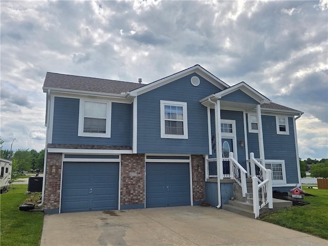 657 SW Tisha Ln, Grain Valley, MO 64029 - view of front of property featuring driveway, an attached garage, cooling unit, and brick siding