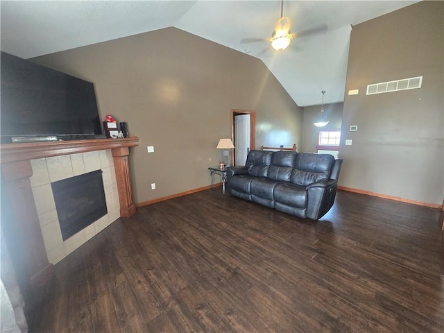 657 SW Tisha Ln, Grain Valley, MO 64029 - living area with a ceiling fan, wood finished floors, vaulted ceiling, a tiled fireplace, and baseboards
