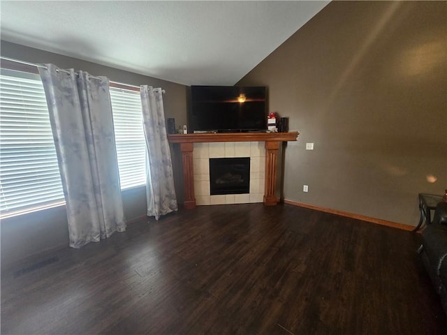 657 SW Tisha Ln, Grain Valley, MO 64029 - unfurnished living room with wood finished floors, vaulted ceiling, and a tiled fireplace