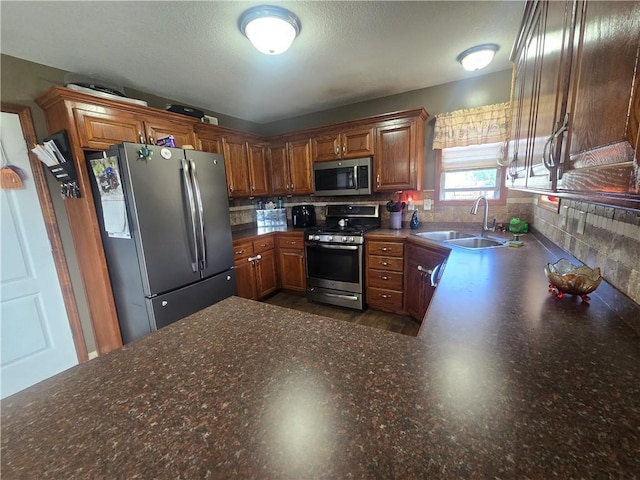 657 SW Tisha Ln, Grain Valley, MO 64029 - kitchen featuring stainless steel appliances, a sink, brown cabinets, and dark countertops