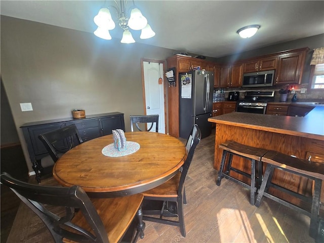 657 SW Tisha Ln, Grain Valley, MO 64029 - dining room featuring wood finished floors and a chandelier