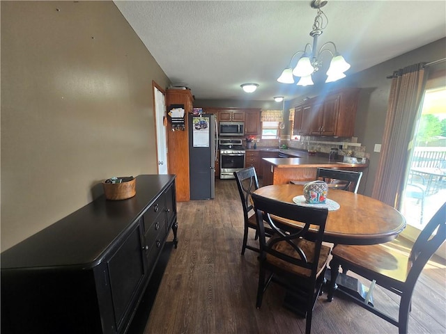 657 SW Tisha Ln, Grain Valley, MO 64029 - dining space featuring a chandelier, dark wood-style floors, and a textured ceiling