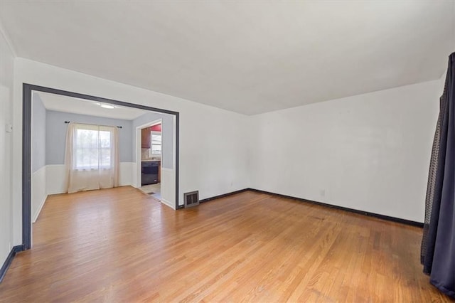 2504 NE 60th St, Gladstone, MO 64118 - empty room with light wood-style floors, baseboards, and a wainscoted wall