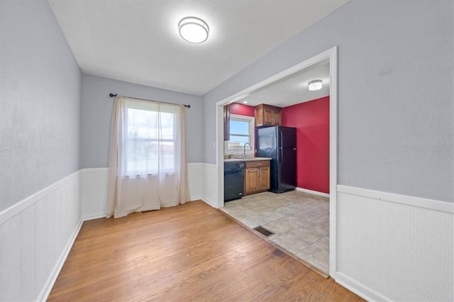 2504 NE 60th St, Gladstone, MO 64118 - unfurnished dining area with light wood-style flooring, wainscoting, and a sink