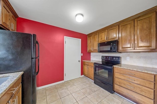 2504 NE 60th St, Gladstone, MO 64118 - kitchen with black appliances, brown cabinetry, and light stone counters