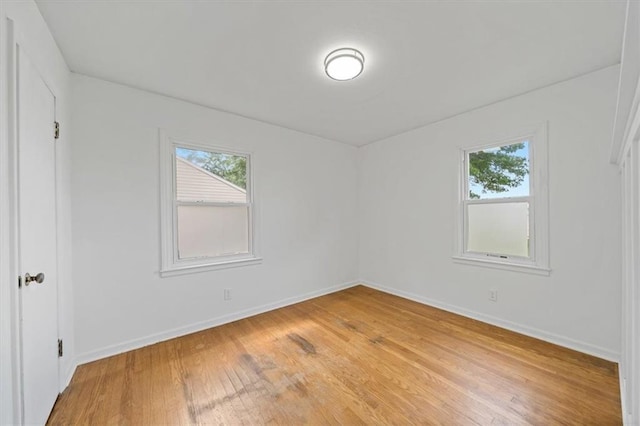 2504 NE 60th St, Gladstone, MO 64118 - unfurnished bedroom with light wood-style floors, multiple windows, and baseboards